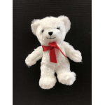 White teddy bear with a red ribbon on a dark background
