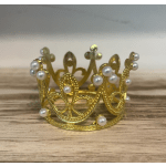 Gold decorative crown with pearl accents on a wooden surface