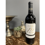 Bottle of red wine on a table with blurred decor in the background
