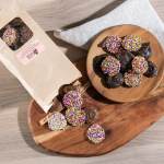 Chocolate-covered treats with colorful sprinkles on wooden boards