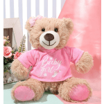 Teddy bear in a pink "Baby girl" shirt beside a small floral arrangement