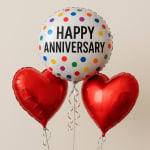 Three balloons, including a "Happy Anniversary" balloon and two red heart balloons.