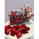 Clear gift box with red rose petals and a decorative ribbon bow