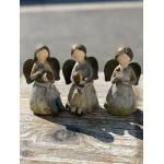 Three angel figurines holding small flowers