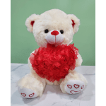 White teddy bear holding a red heart decoration