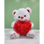 White teddy bear holding a red heart-shaped decoration