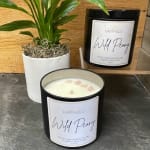 Potted plant beside two black candles labeled Wild Peony