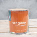 Potted oregano plant in a clear glass container with an orange label