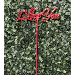 Red "I Love You" sign on a green leaf wall