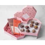 Pink heart-shaped gift boxes with chocolates and candy bars