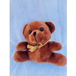 Brown teddy bear with a gold ribbon on a light blue background