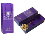 Gold-colored rose in a purple gift box with matching bag
