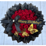 Red rose bouquet with black wrapping, a birthday ribbon, and butterfly decorations