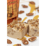 Two nut-topped dessert squares with syrup and a bottle behind them