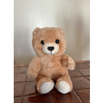 Plush teddy bear sitting on a tiled floor