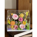 Mixed flowers arranged in a clear acrylic box
