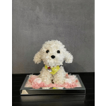 White flower-covered dog figurine in a mirrored tray with pink flowers