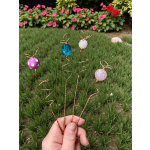 Hand holding four wire flower picks with colorful beads