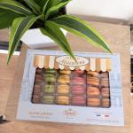 Potted green plant beside a box of French macarons