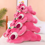 Stack of pink teddy bear plush toys on a bed