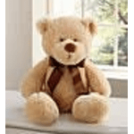 Teddy bear with a brown ribbon sitting on a table