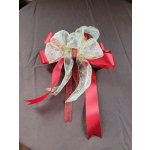 Red ribbon bow with sheer gold-trimmed overlay on dark fabric