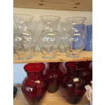 Clear and red glass vases arranged on wooden shelves