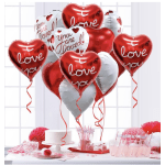 Heart-shaped love balloons above a pink party table