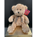 Plush teddy bear with a ribbon sitting on a gold textured box