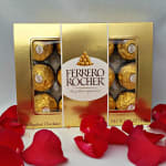 Ferrero Rocher chocolate box with red rose petals scattered in front