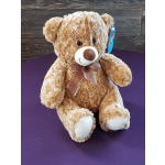 Plush teddy bear with a ribbon bow sitting on a purple surface