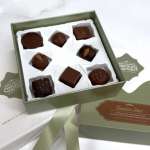 Box of assorted chocolates with a ribbon and branded packaging