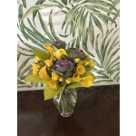 Yellow calla lilies, yellow spray roses, and purple ornamental cabbage in a clear glass vase