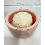 White rose-shaped candle in a pink ceramic pot