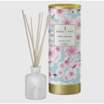 Reed diffuser with a floral-patterned tube and white bottle with reeds