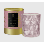 Pink glass candle in a faceted holder beside its gold-and-pink box