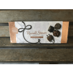 Box of assorted milk and dark chocolates on a wooden surface