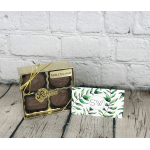 Box of milk chocolates tied with gold ribbon beside a leafy business card