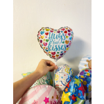 Heart-shaped balloon with colorful hearts and the words "Hugs and kisses"