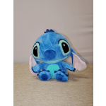 Blue plush Stitch toy with large ears sitting on a surface