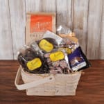 Gift basket filled with assorted packaged chocolates and pretzels in a light woven basket