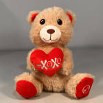 Plush teddy bear holding a red heart with "XOXO" text