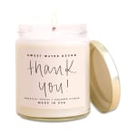 Labeled candle in a glass jar with its lid beside it