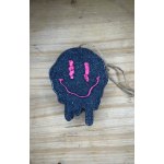 Black skull-shaped hanging ornament with a pink smiley face