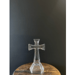 Clear glass cross-shaped vase on a wooden table