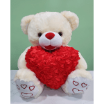 White teddy bear holding a red heart