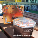 Two boxes of assorted chocolates on a wooden table