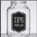 Clear glass tip jar with a black label reading tips thank you