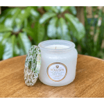 White scented candle in a glass jar with a patterned lid