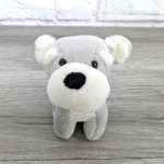 Gray and white plush teddy bear on a wood surface